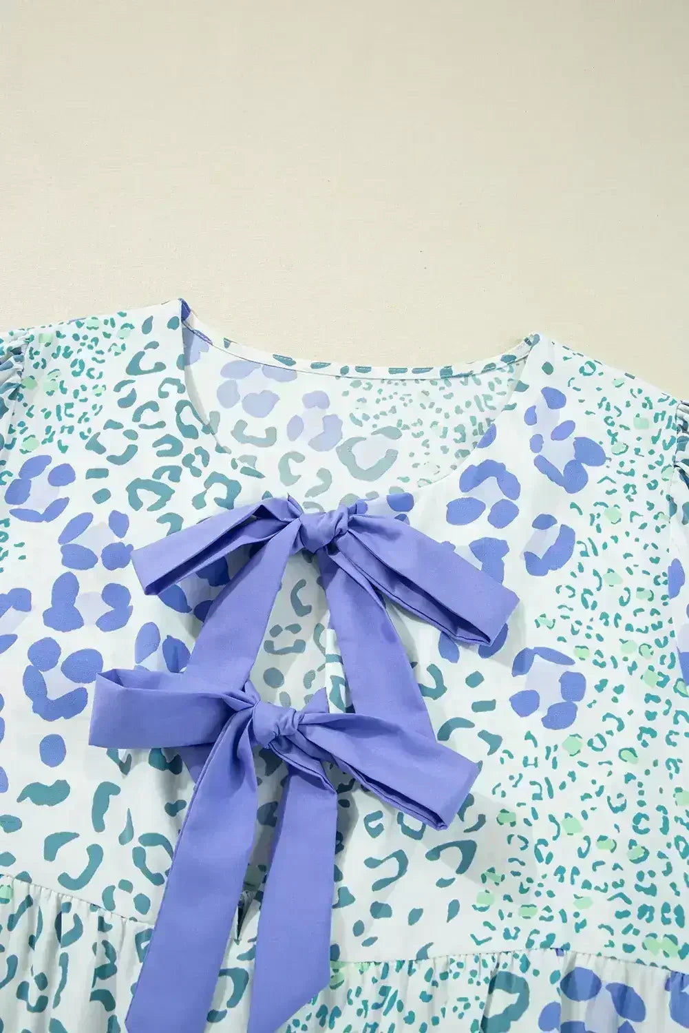 Robe courte bleu ciel à motif léopard, ornée d'un nœud sur le devant et de manches bouffantes
