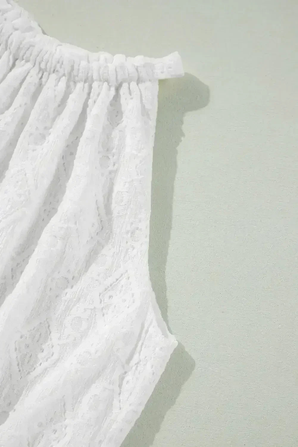 Robe courte blanche sans manches en dentelle avec nœud ajouré au dos et taille nouée