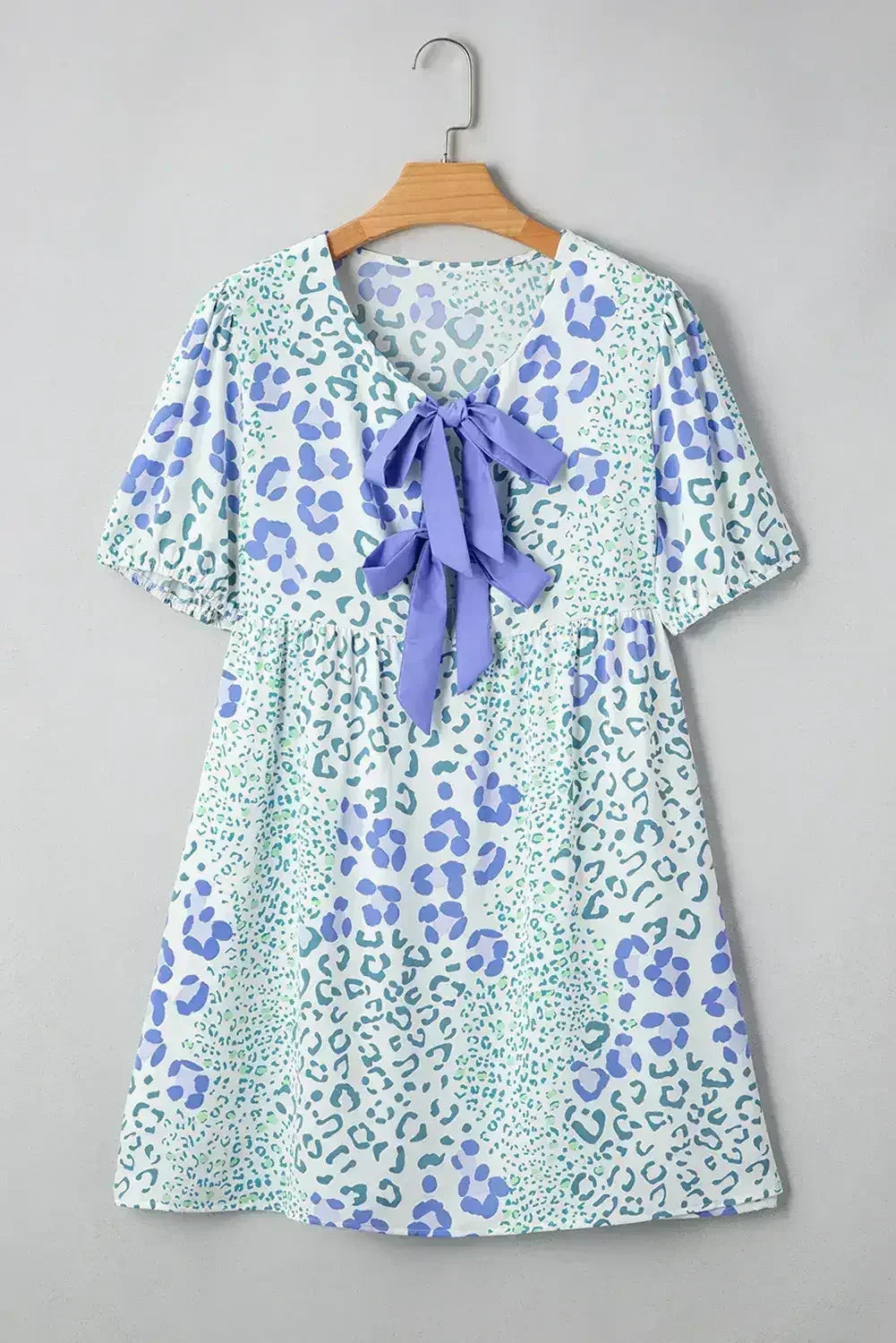 Robe courte bleu ciel à motif léopard, ornée d'un nœud sur le devant et de manches bouffantes