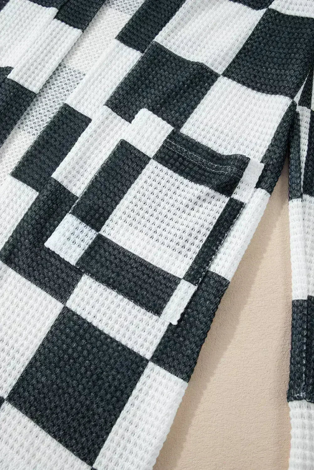 Cardigan ouvert en maille gaufrée à carreaux noirs avec trous pour les pouces