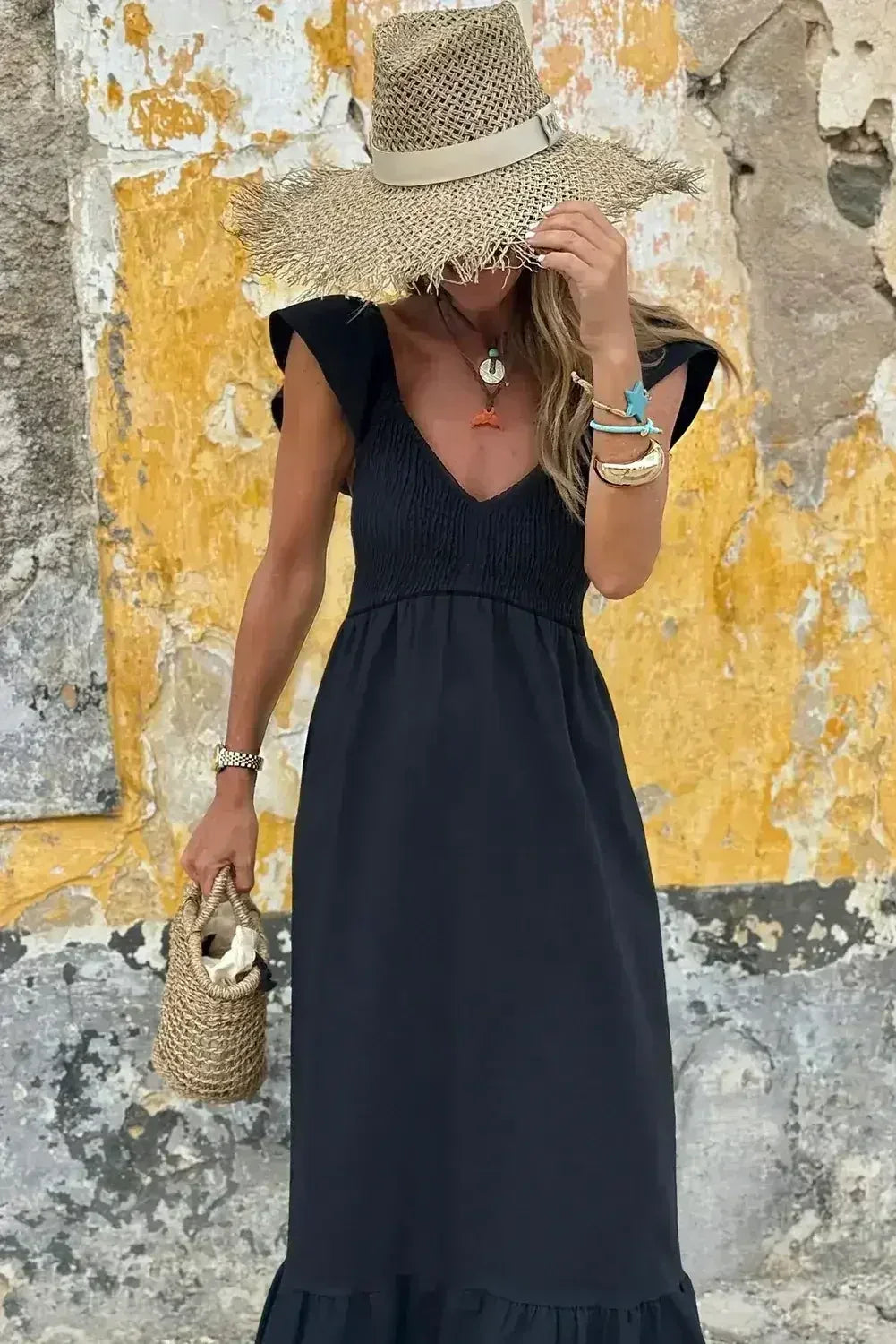Robe longue noire à volants, col en V, taille haute et buste smocké