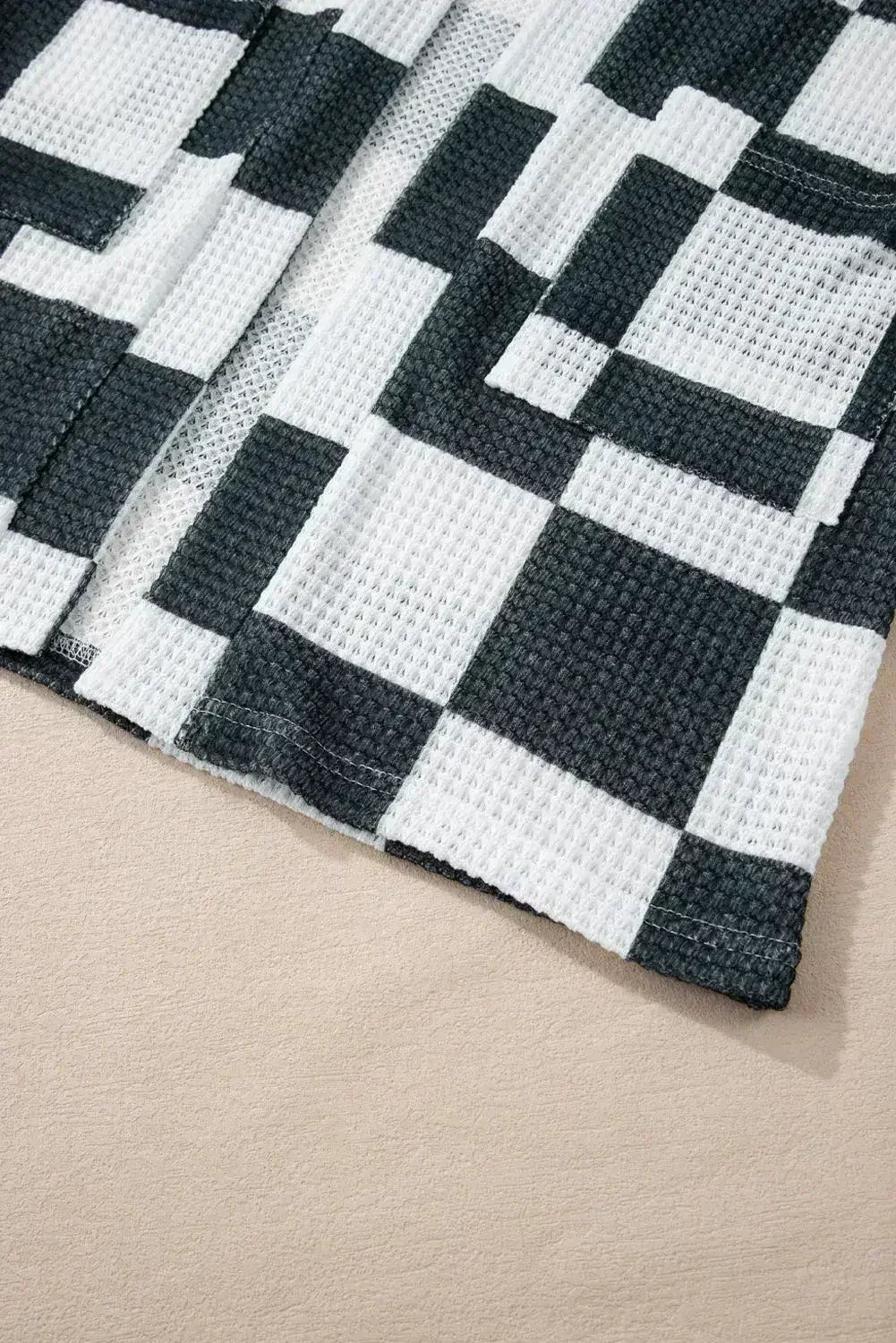 Cardigan ouvert en maille gaufrée à carreaux noirs avec trous pour les pouces