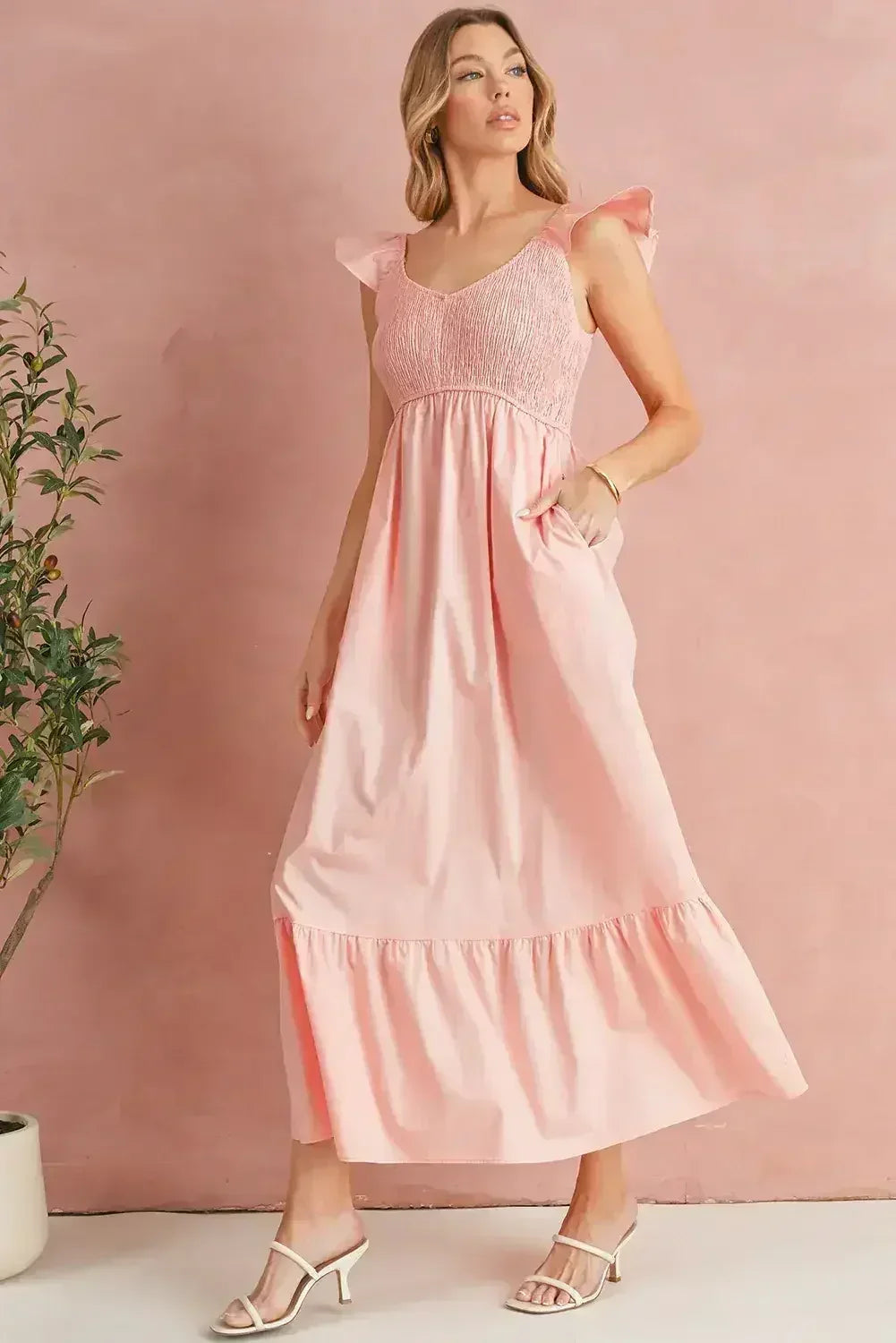 Robe longue noire à volants, col en V, taille haute et buste smocké