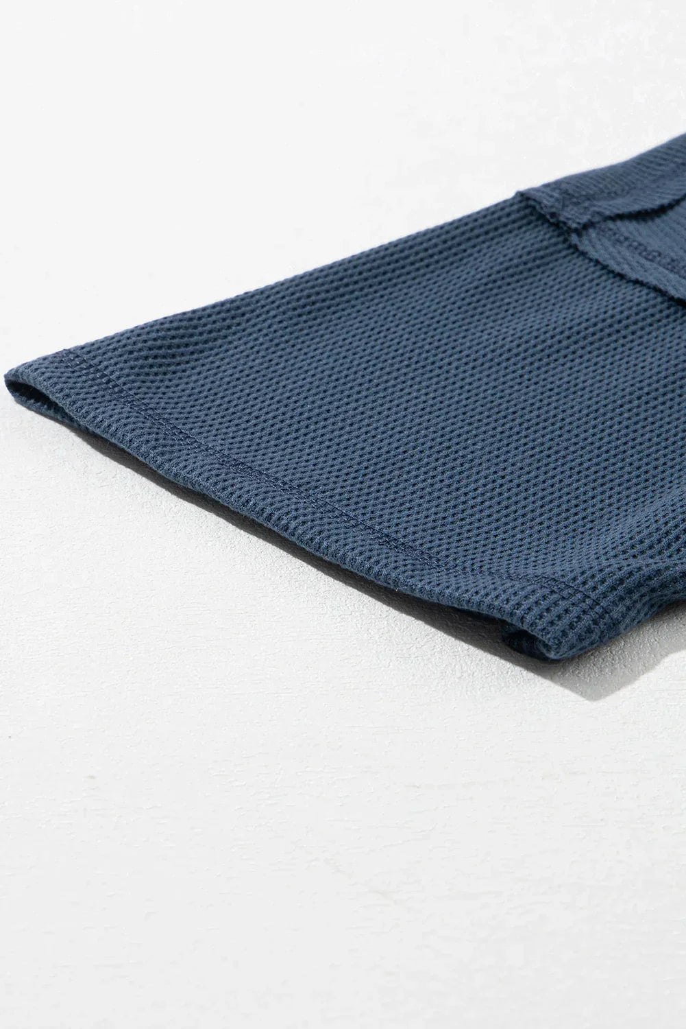 Haut texturé gaufré bleu à col en V avec manches tombantes et coutures apparentes