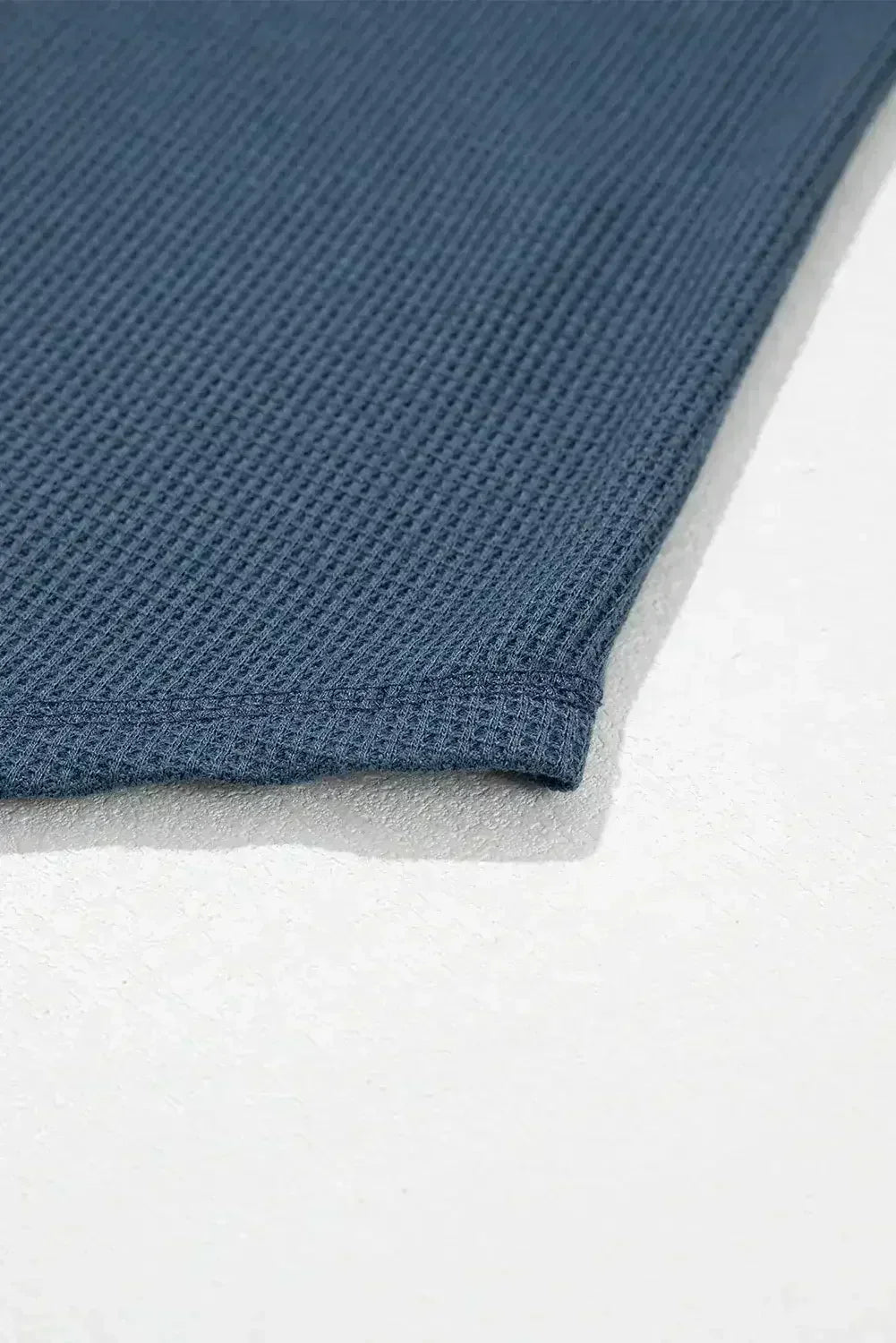 Haut texturé gaufré bleu à col en V avec manches tombantes et coutures apparentes
