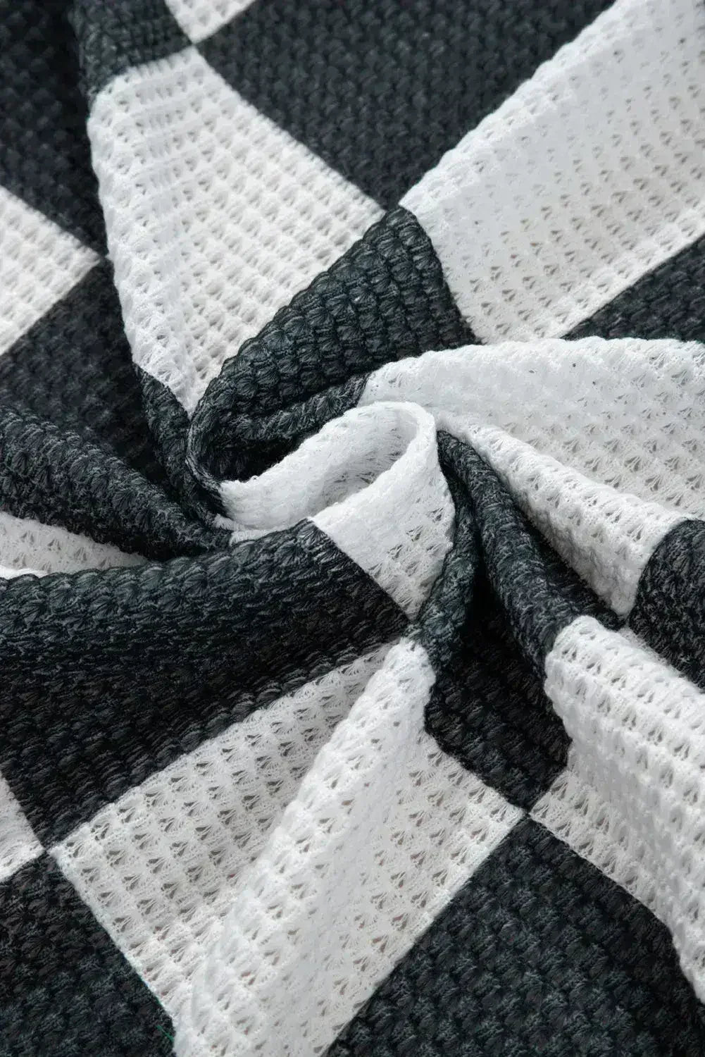 Cardigan ouvert en maille gaufrée à carreaux noirs avec trous pour les pouces
