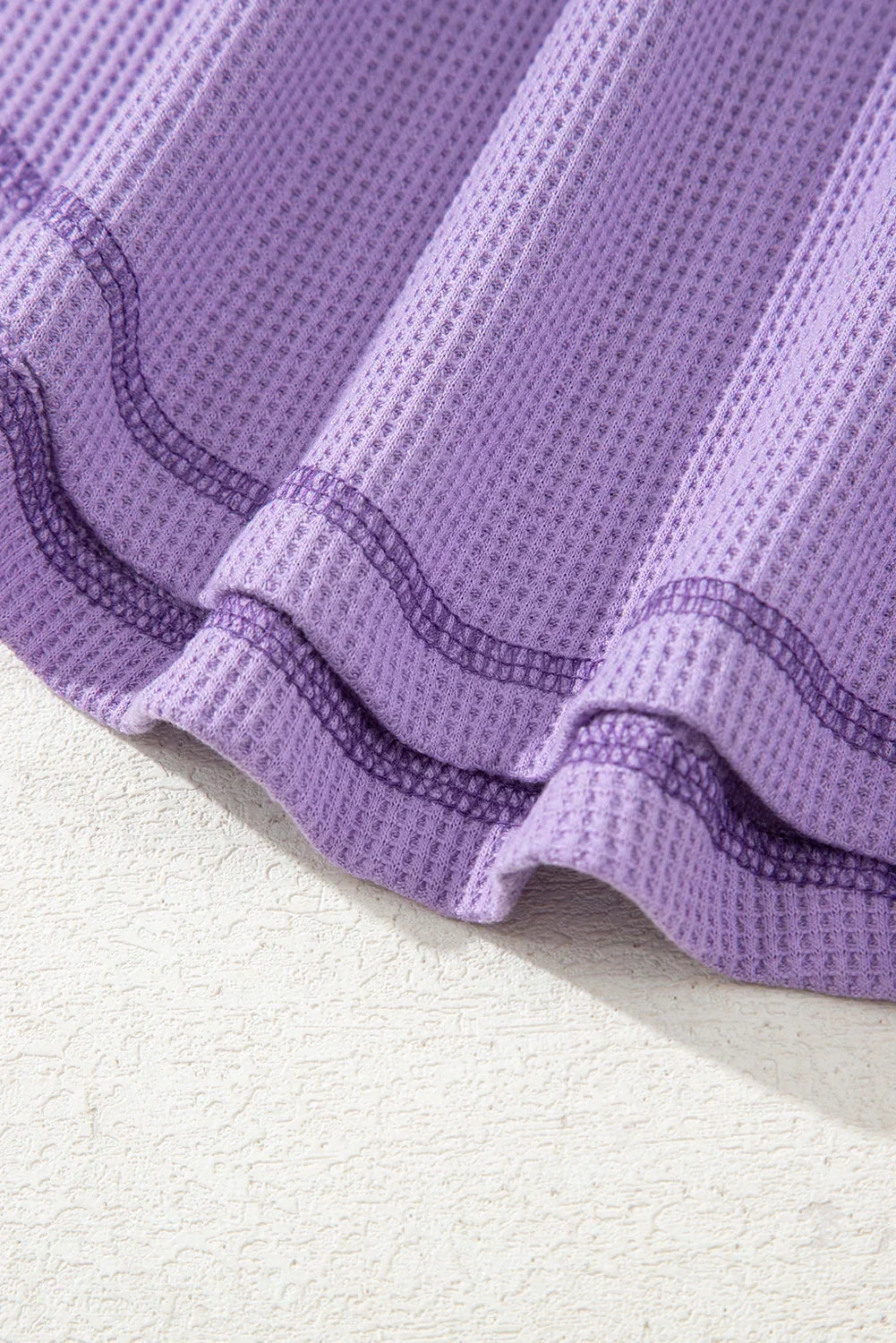 Haut texturé gaufré bleu à col en V avec manches tombantes et coutures apparentes