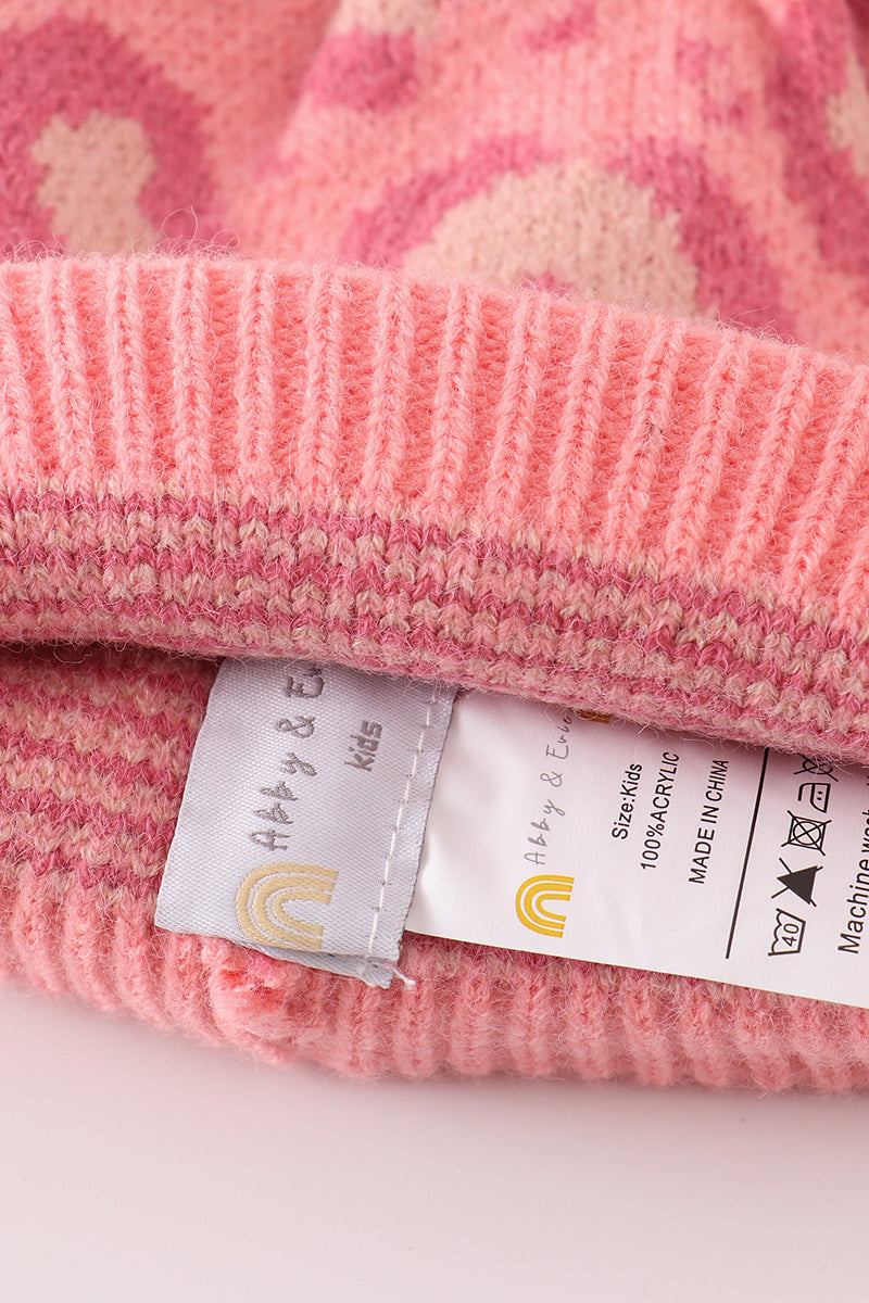 Bonnet à pompon rose, motif léopard, en maille torsadée