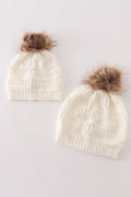 Bonnet torsadé à pompon couleur ivoire