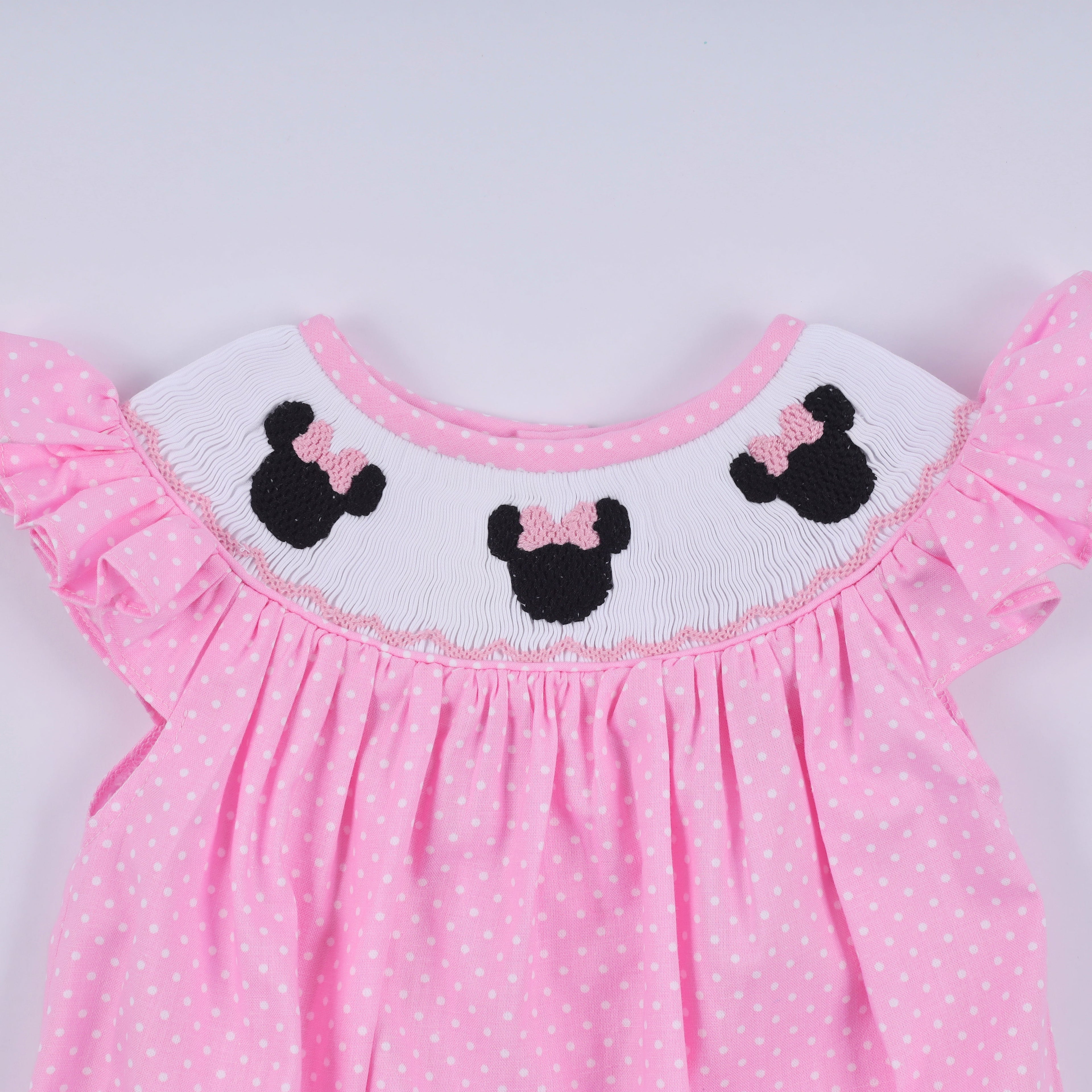 Barboteuse rose à smocks main, pois et volants