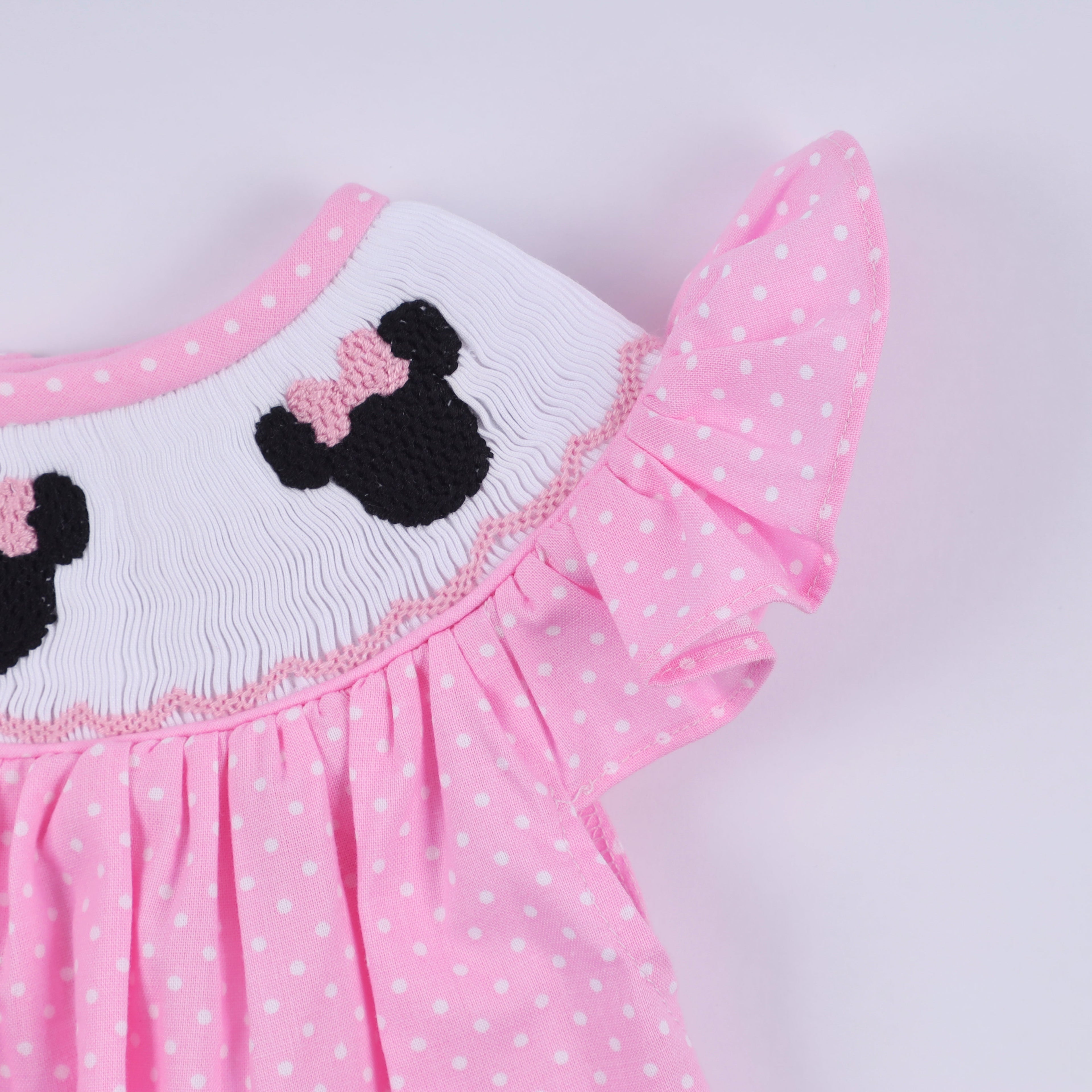 Barboteuse rose à smocks main, pois et volants