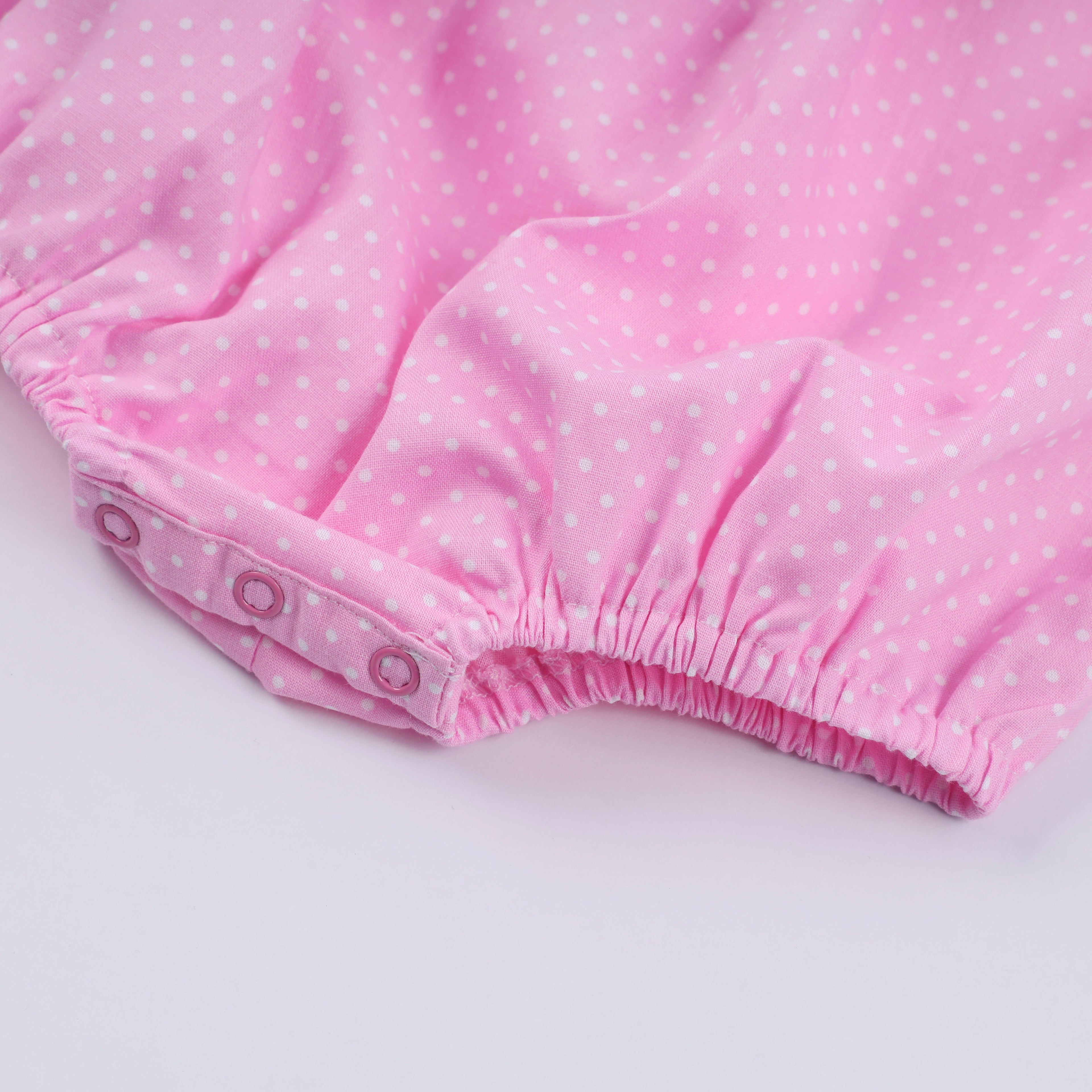 Barboteuse rose à smocks main, pois et volants