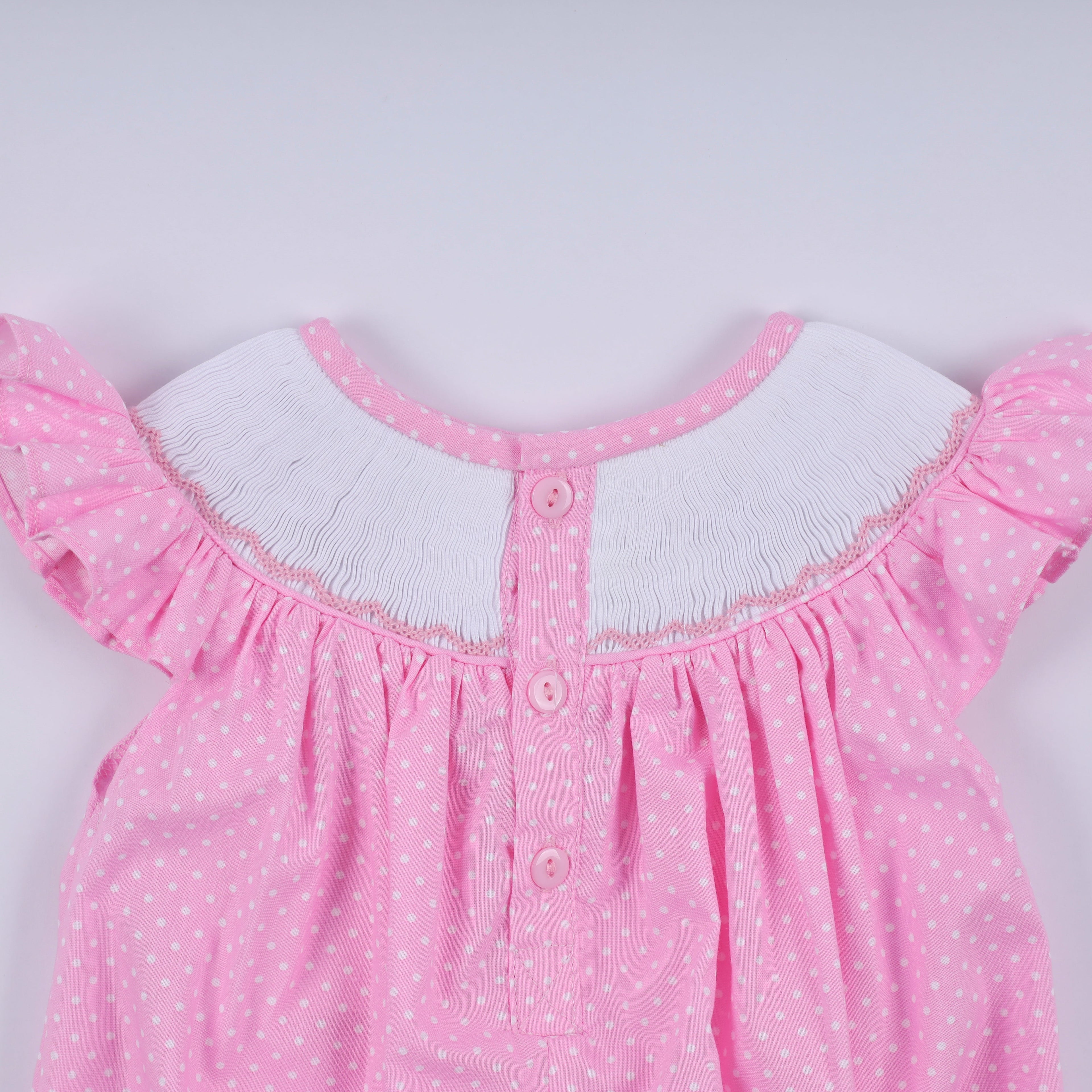 Barboteuse rose à smocks main, pois et volants