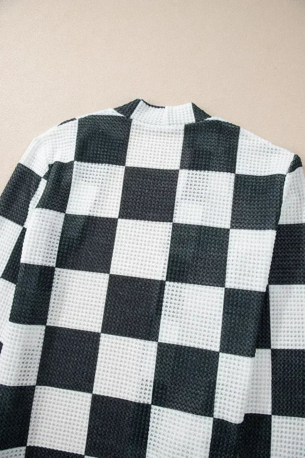 Cardigan ouvert en maille gaufrée à carreaux noirs avec trous pour les pouces