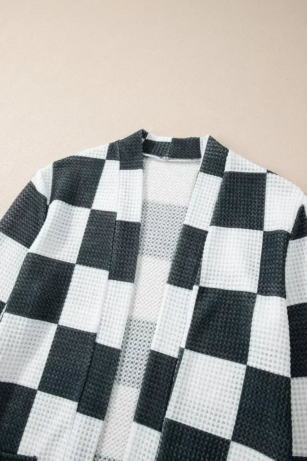Cardigan ouvert en maille gaufrée à carreaux noirs avec trous pour les pouces