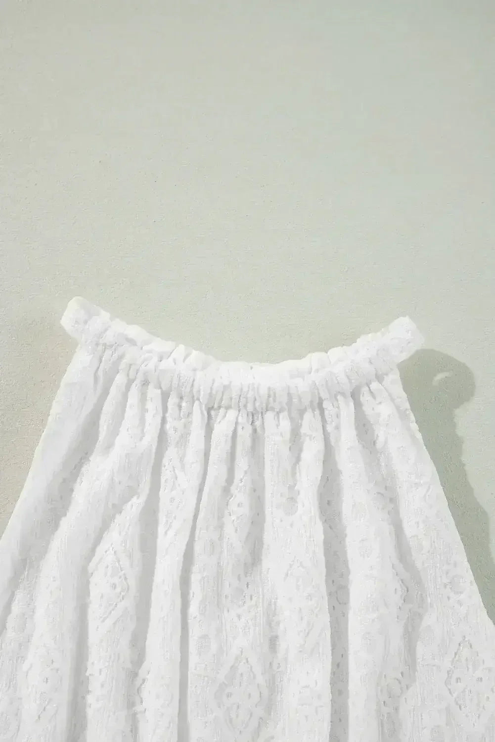 Robe courte blanche sans manches en dentelle avec nœud ajouré au dos et taille nouée