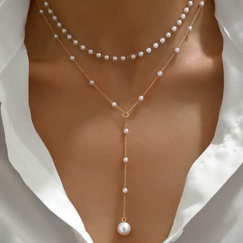 Élégant collier pendentif double couche de style vintage avec des accents de perles d'imitation et un pompon.