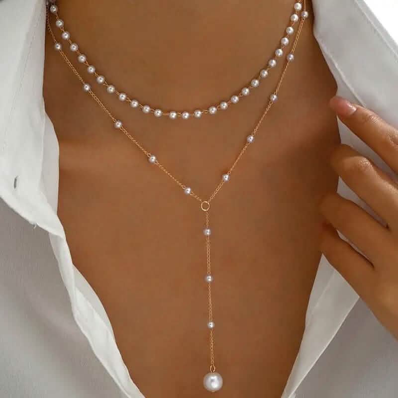 Élégant collier pendentif double couche de style vintage avec des accents de perles d'imitation et un pompon.