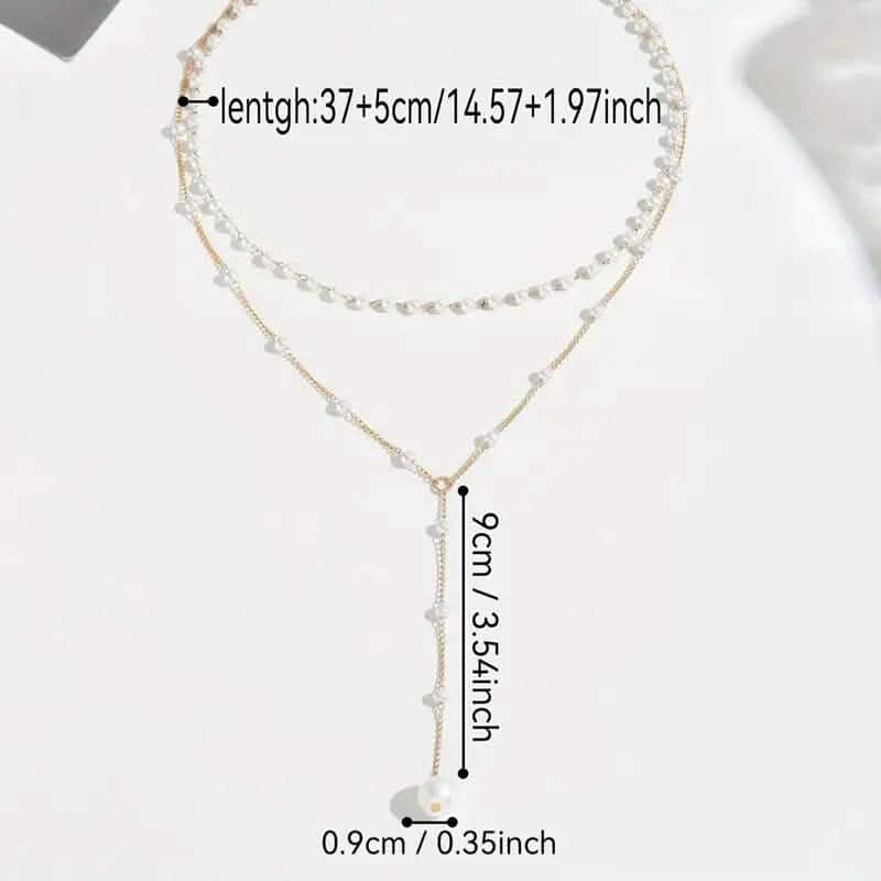 Élégant collier pendentif double couche de style vintage avec des accents de perles d'imitation et un pompon.