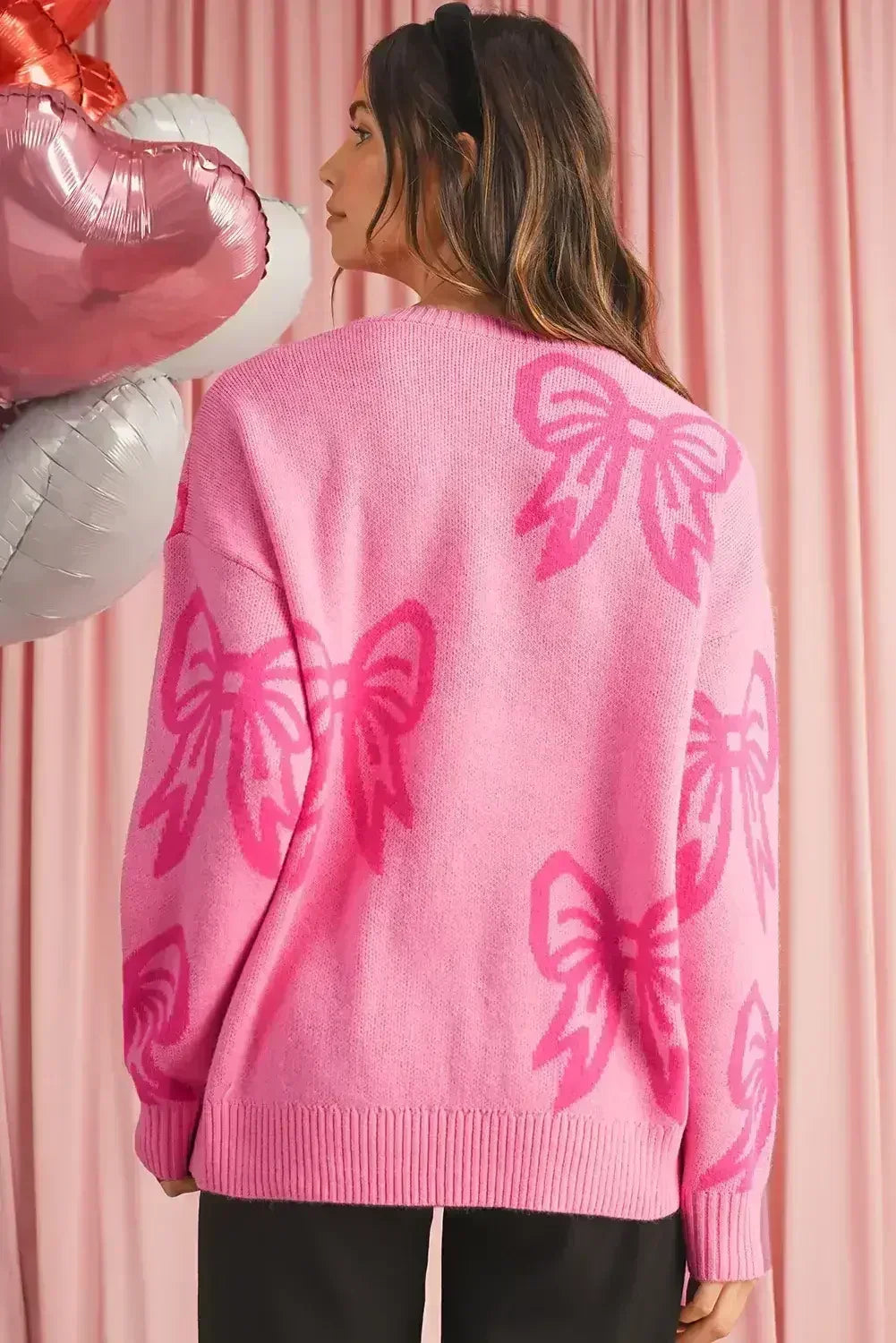 Pull ample à manches tombantes motif nœuds roses