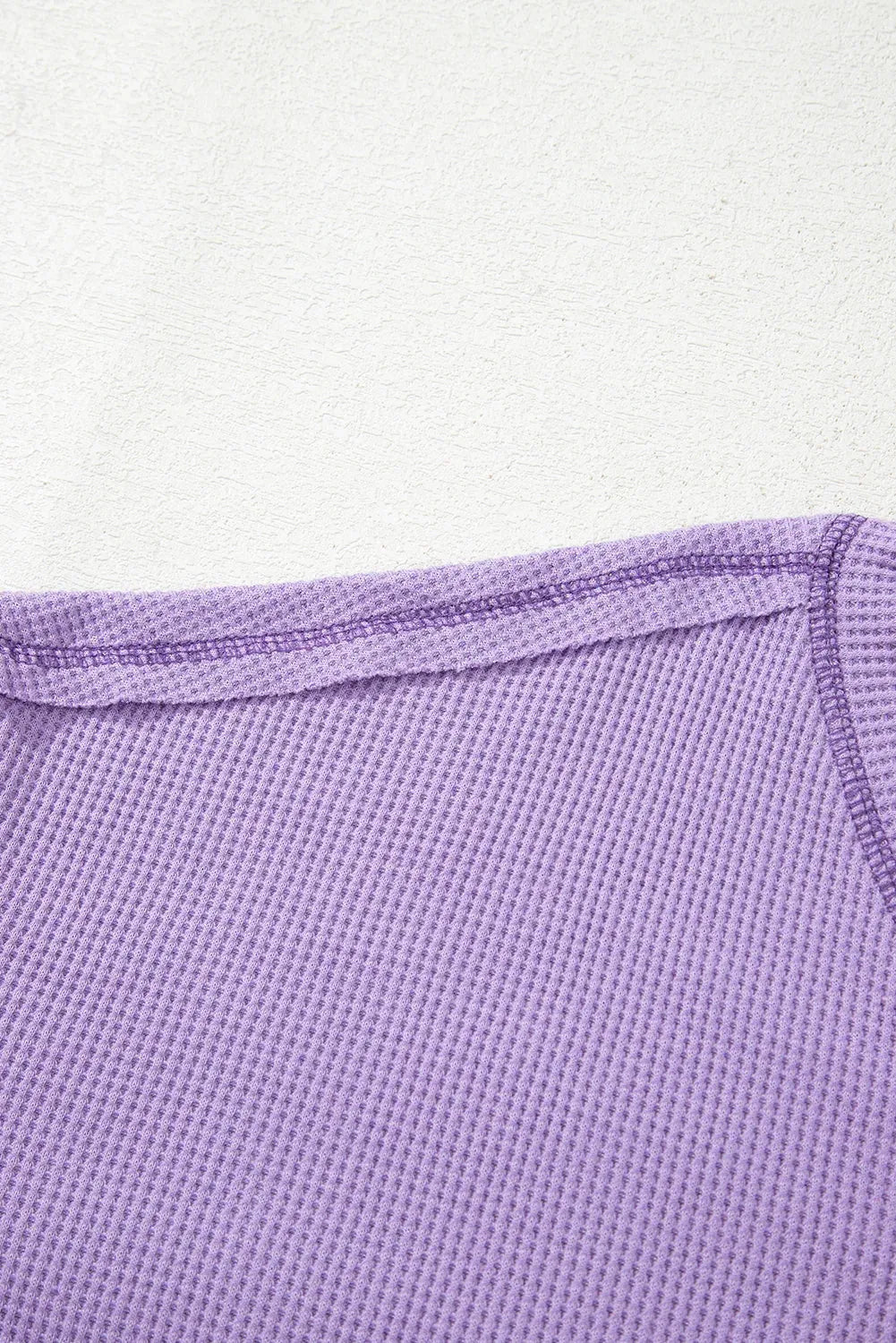 Haut texturé gaufré bleu à col en V avec manches tombantes et coutures apparentes
