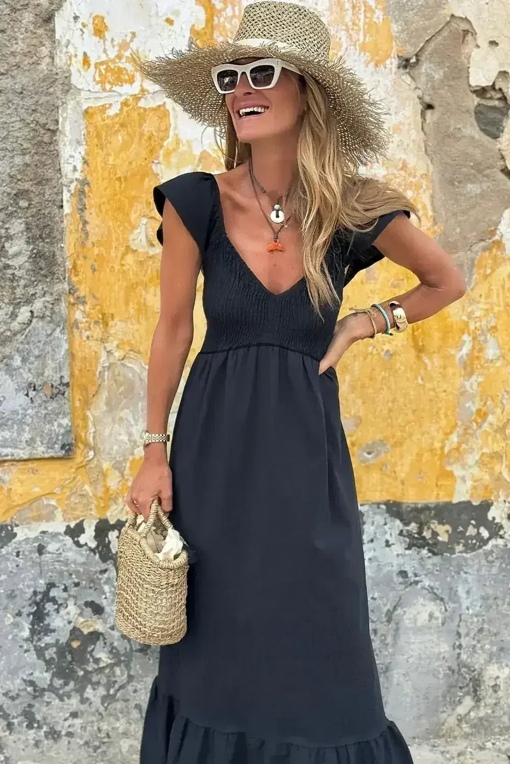 Robe longue noire à volants, col en V, taille haute et buste smocké
